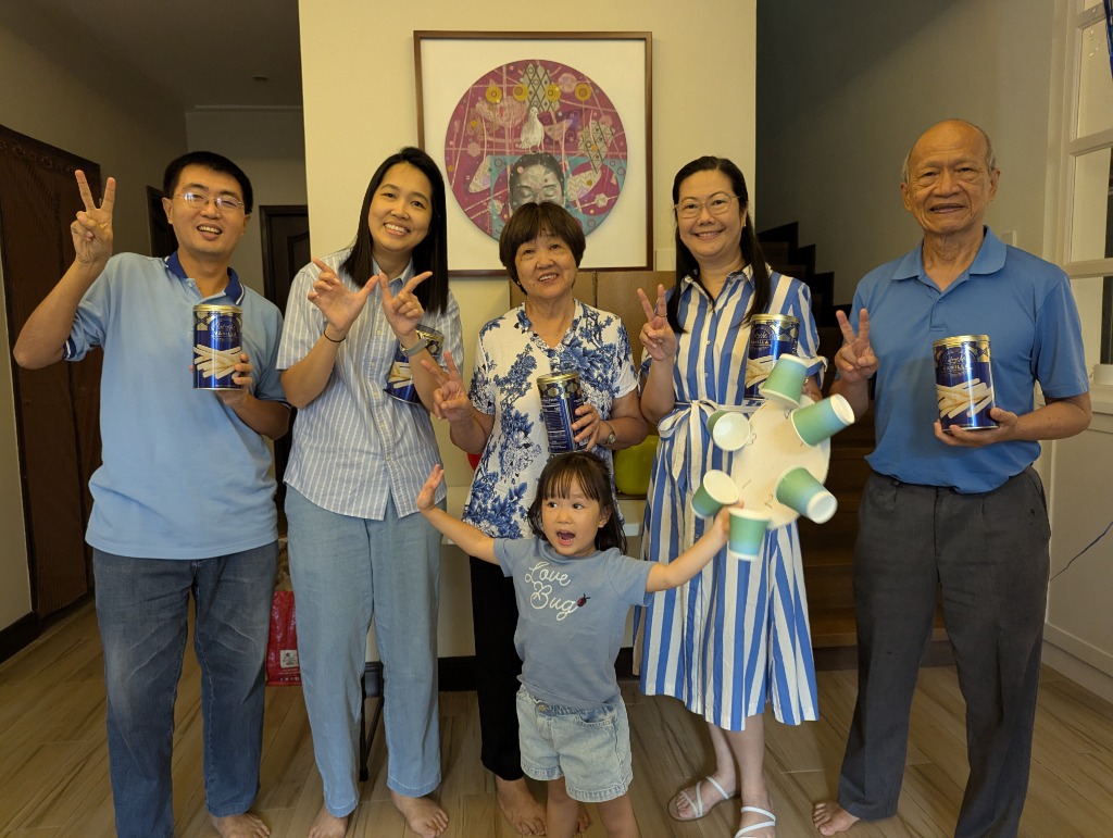 Family group photo indoors holding wafer stick tin cans and celebrating with peace signs